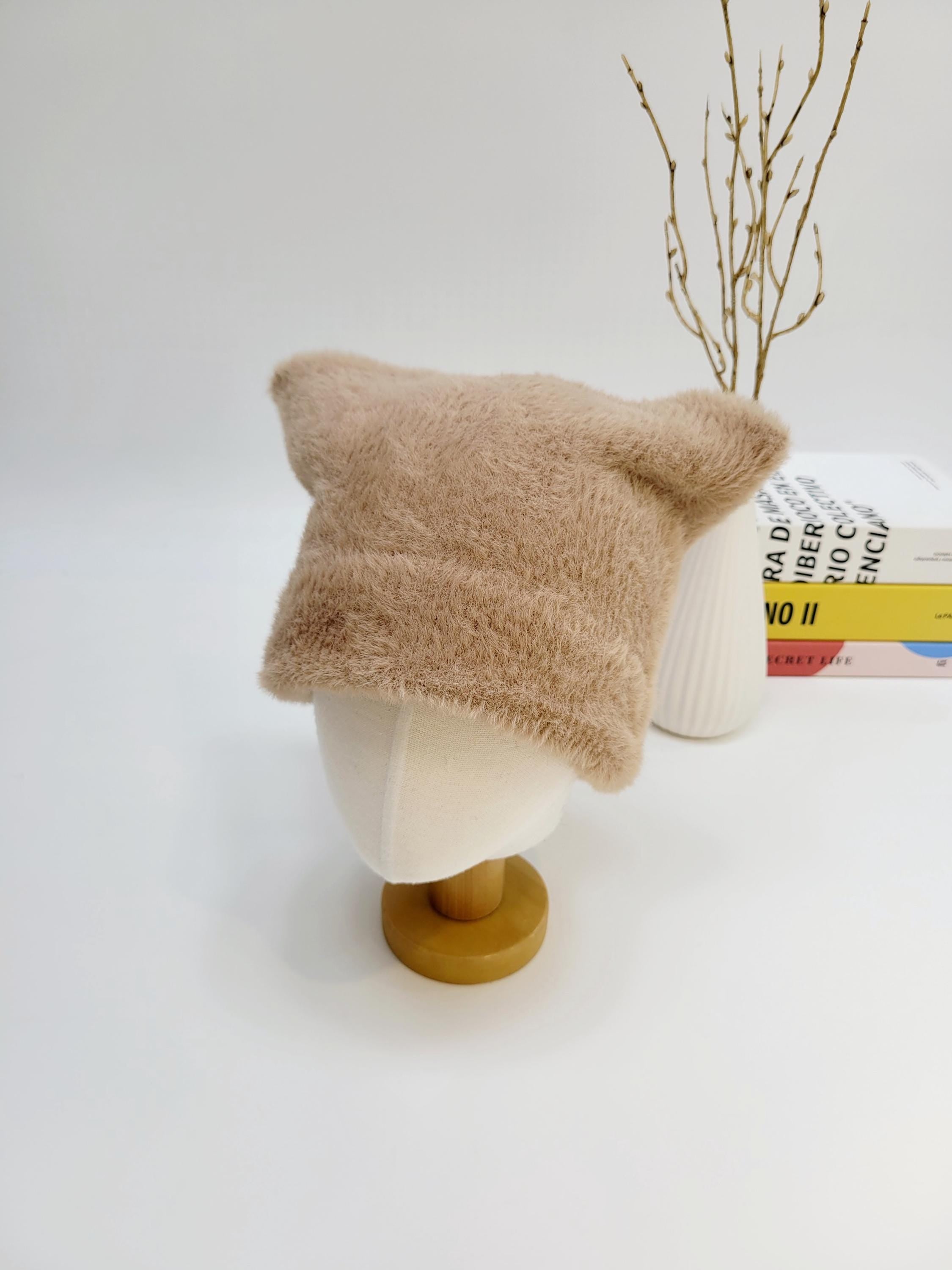 Tan fuzzy elf in the hat with pointed ears, a cute winter hat for warmth and style.