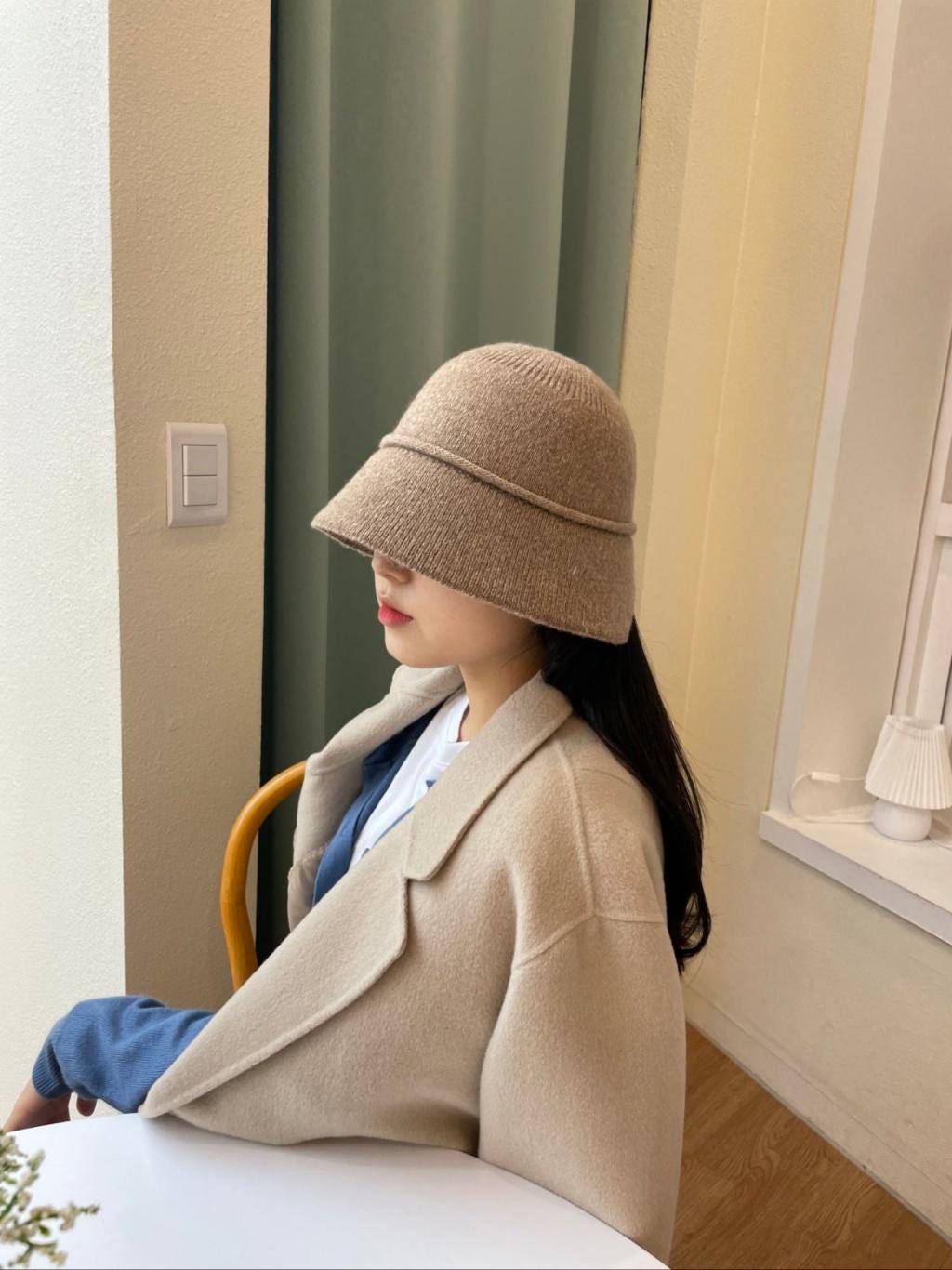 Woman in a stylish beige blazer and blair bucket hat. The hat features a subtle brim detail.