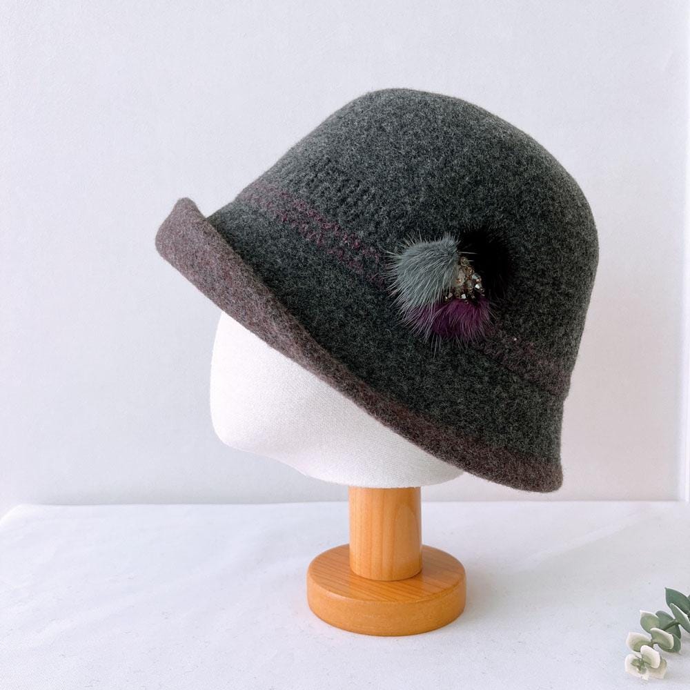 Grey wool my first lady hat with brown brim and decorative pompom detail, displayed on a mannequin head.