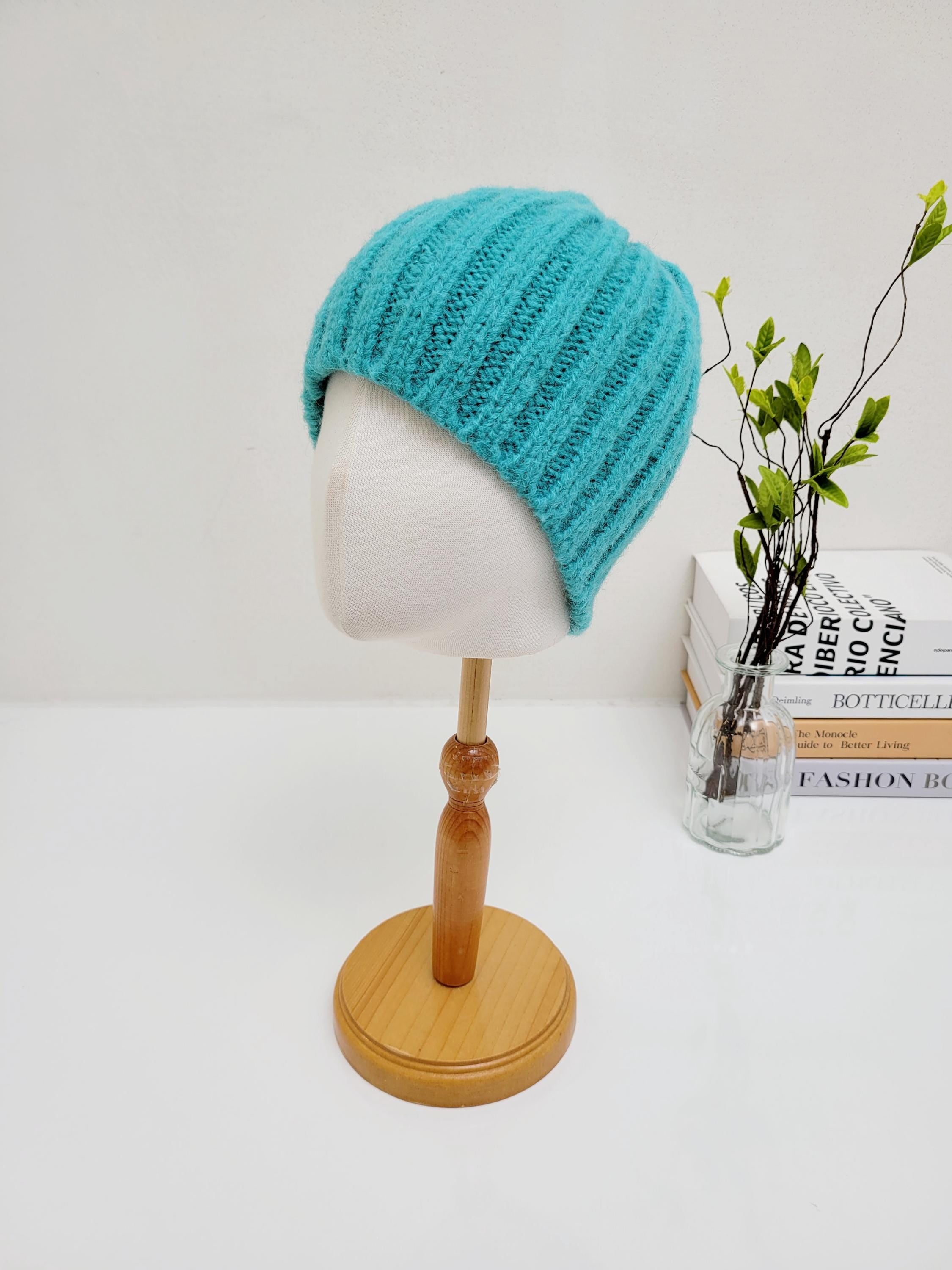 Turquoise wide rib wool beanie on a mannequin. A cozy and stylish headwear option.