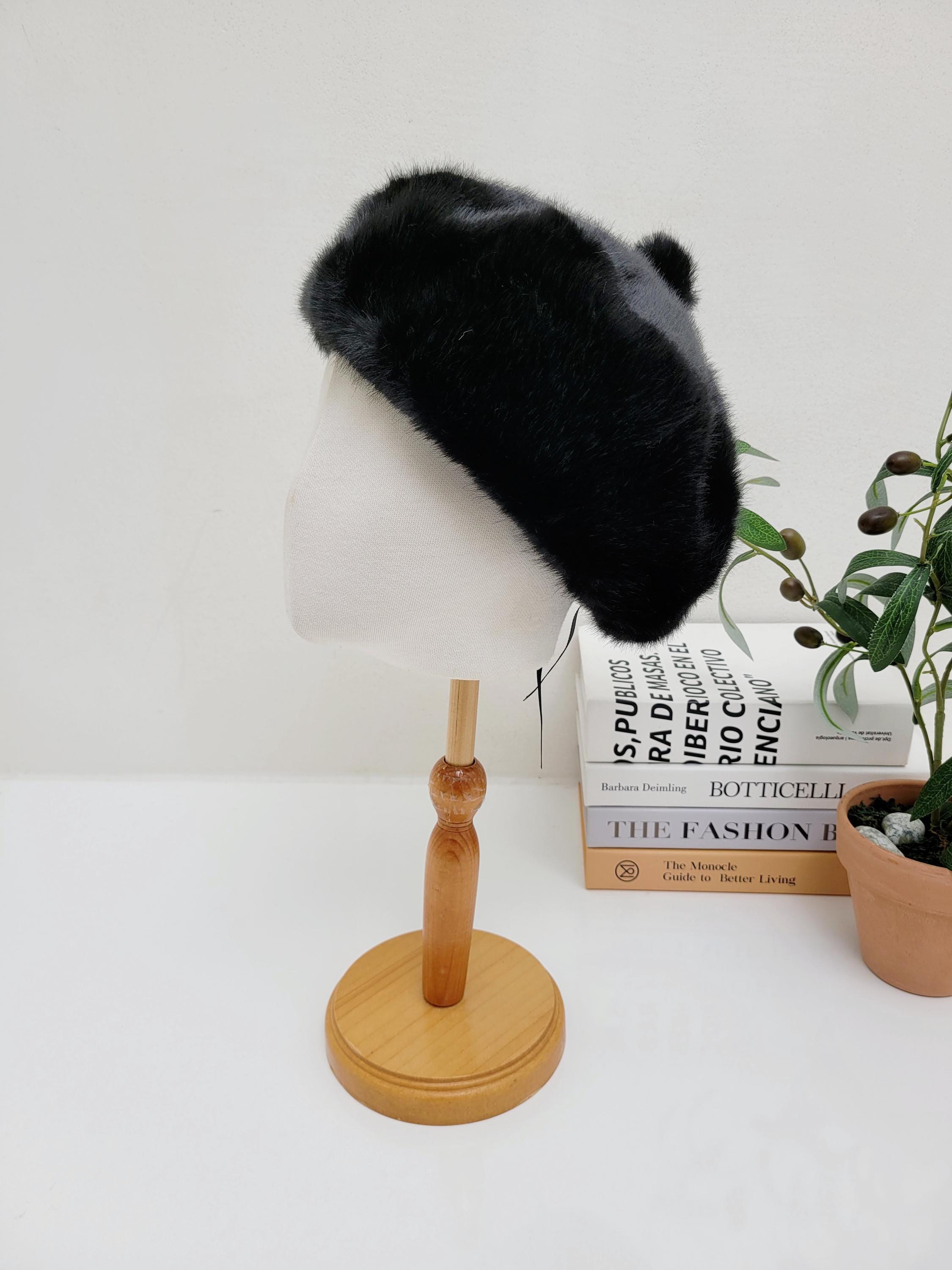 Paris in winter: a plush black faux fur beret with subtle rounded details, displayed on a mannequin head.