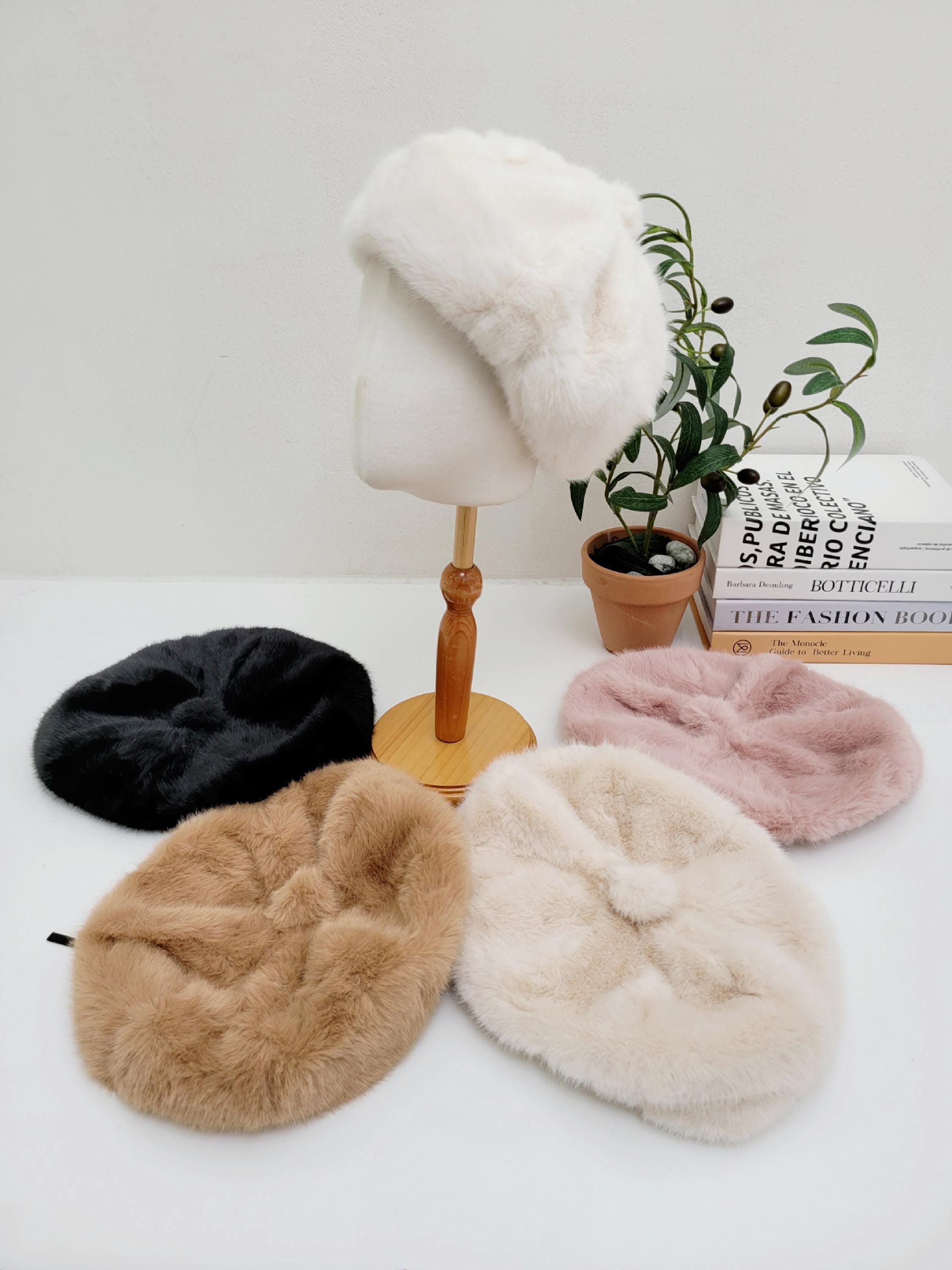 Paris in Winter berets: White faux fur beret on a mannequin, with black, tan, pink, and cream fluffy soft winter hats displayed.