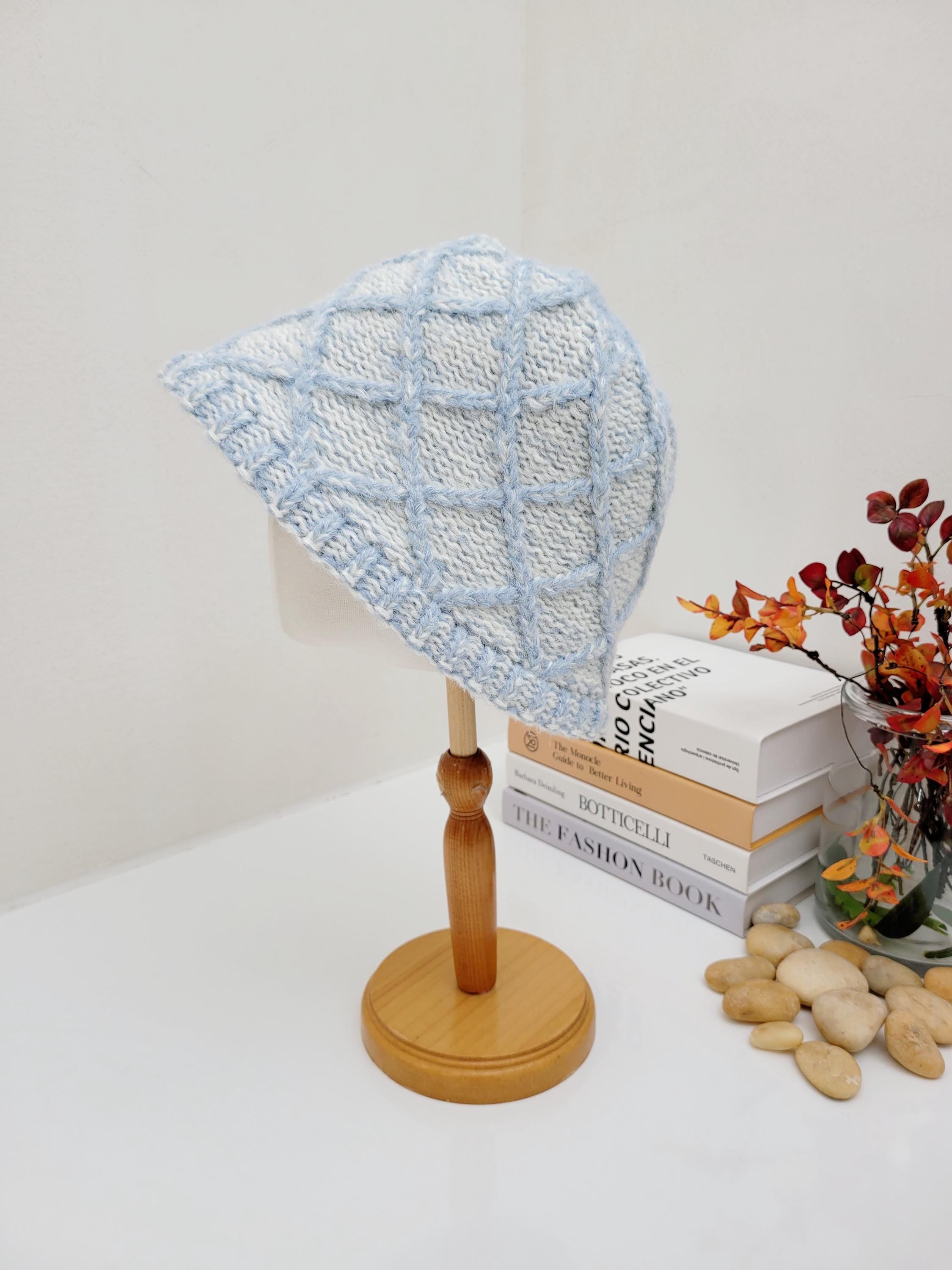 winter in the paris: Blue and white knitted bucket hat with a diamond pattern, displayed on a mannequin head, perfect for winter warmth and style.