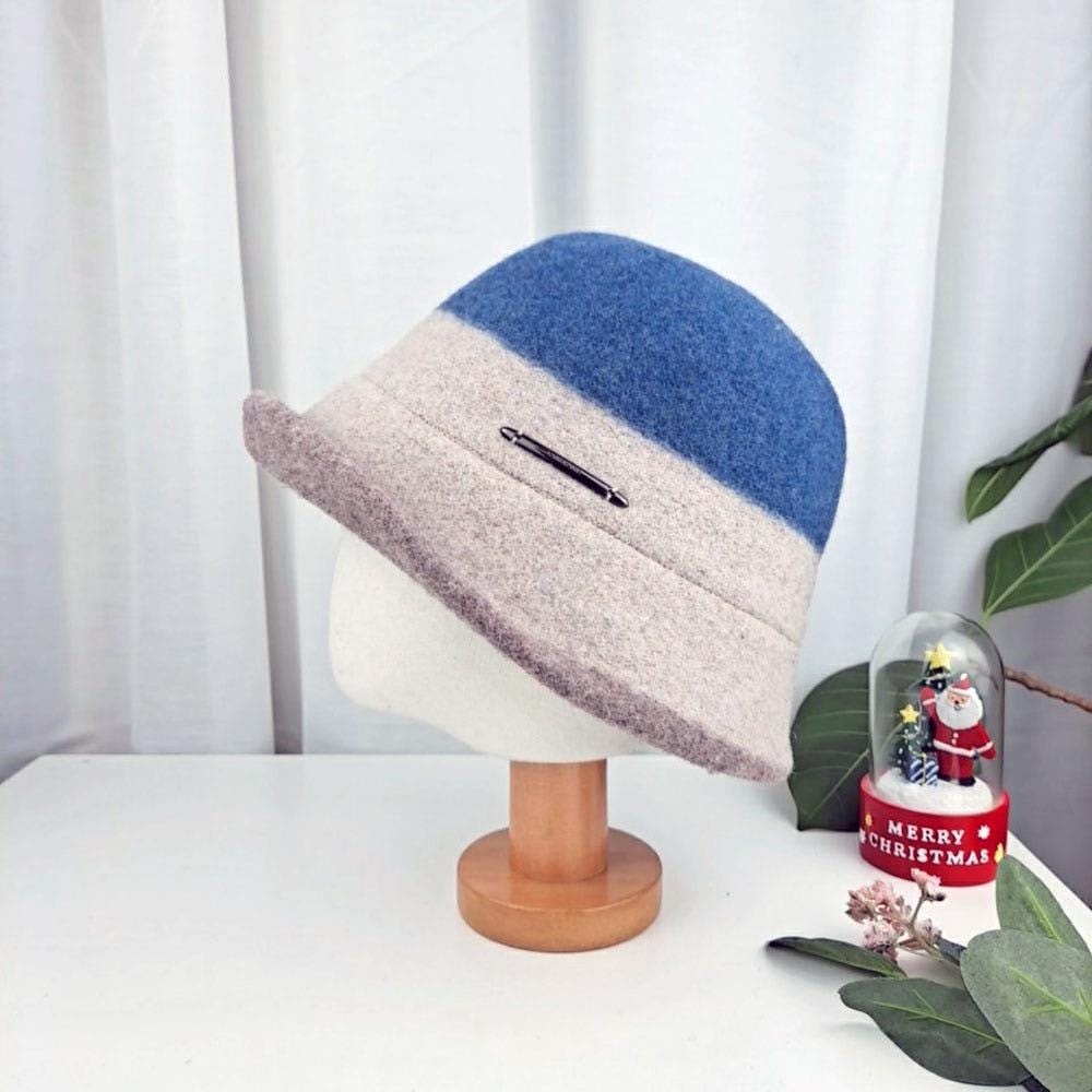 Stylish 3tone wool bucket hat in blue and beige, displayed on a stand. A chic and cozy headwear option.