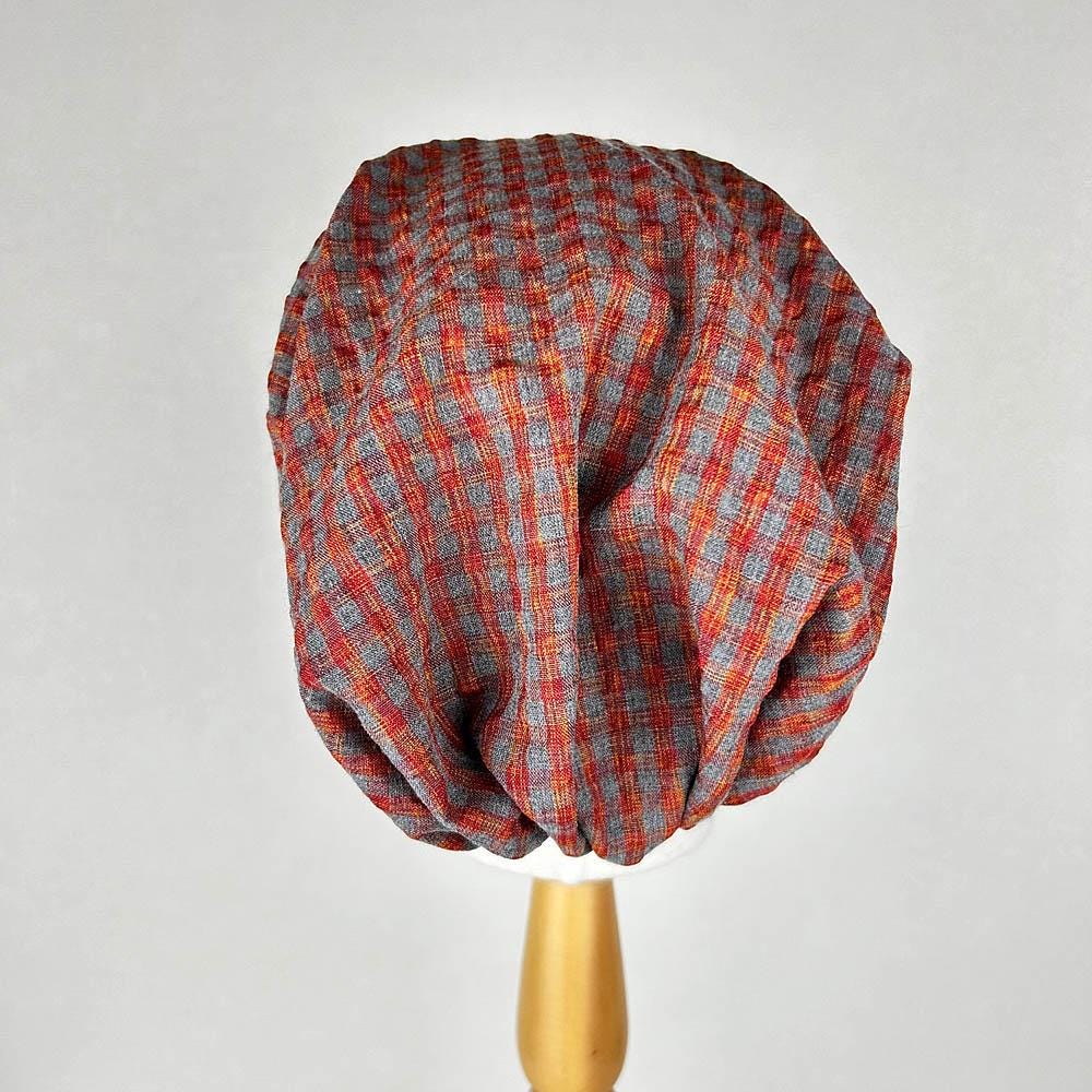 Red and gray chekered beanie, a stylish and comfortable headwear option with a classic pattern.