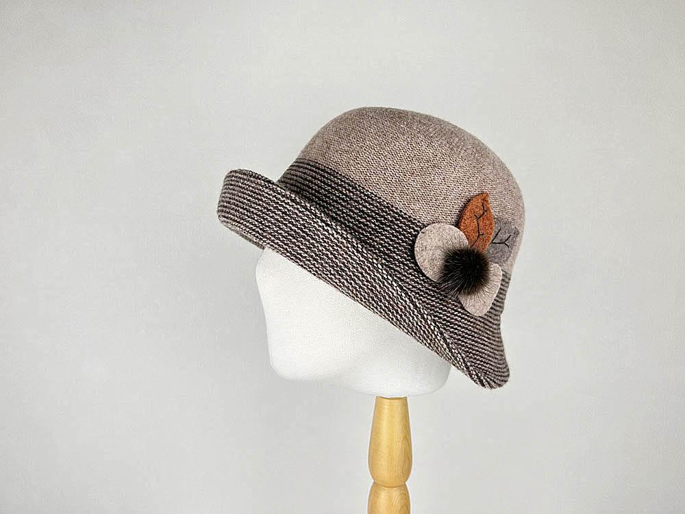 Catherine cloche hat: Taupe tweed hat with a striped brim and a floral accent with a pompom.